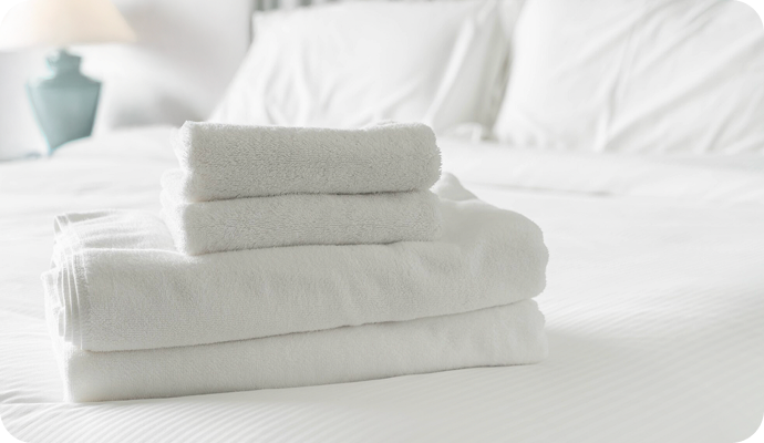 Folded towels on a bed at Alfanar Palace Hotel
